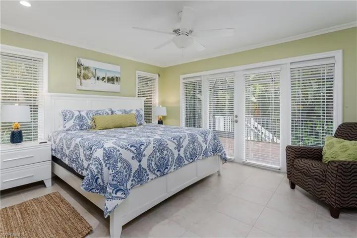 Main bedroom with ceiling fan, crown molding, French door to secondary lanai