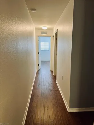 Corridor with dark hardwood / wood-style floors