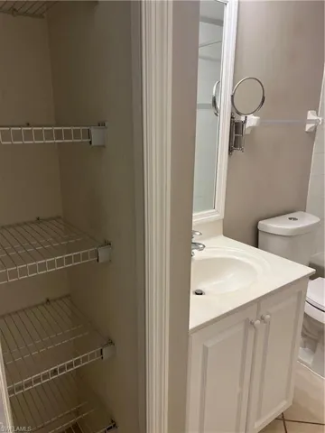 Bathroom featuring tile flooring, vanity, and toilet