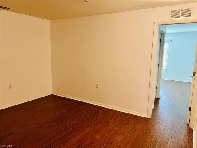 Empty room with dark wood-type flooring