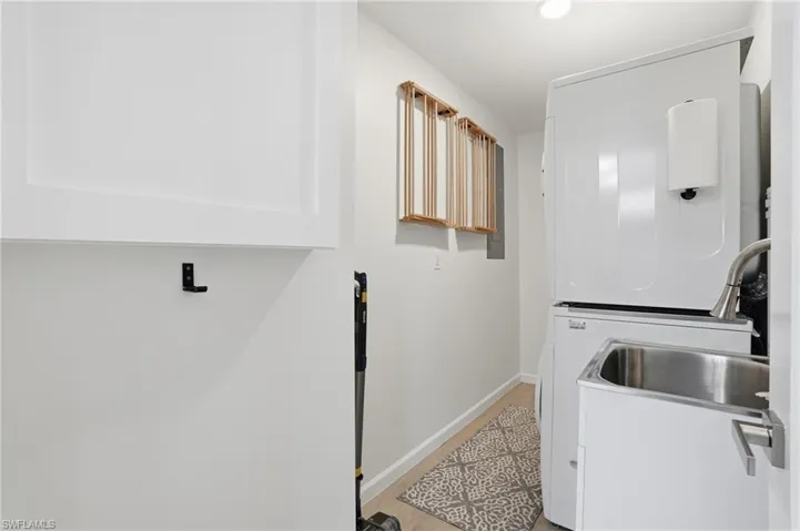 Laundry room featuring light wood tile floors  - Virtually Edited Image