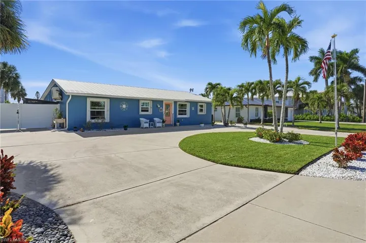 Ranch-style house featuring curved driveway, a front yard, a metal roof - Virtually Edited Image