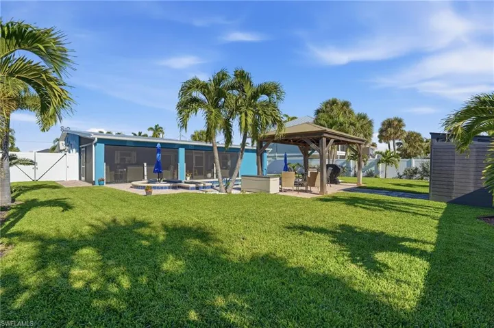 Back of house with a patio area, a fenced backyard, and a gazebo - Virtually Edited Image