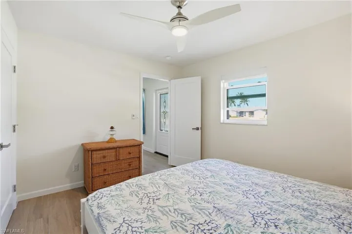 Bedroom featuring light wood tile flooring and ceiling fan - Virtually Edited Image