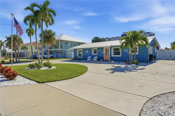 View of front of house with curved driveway and a front lawn - Virtually Edited Image
