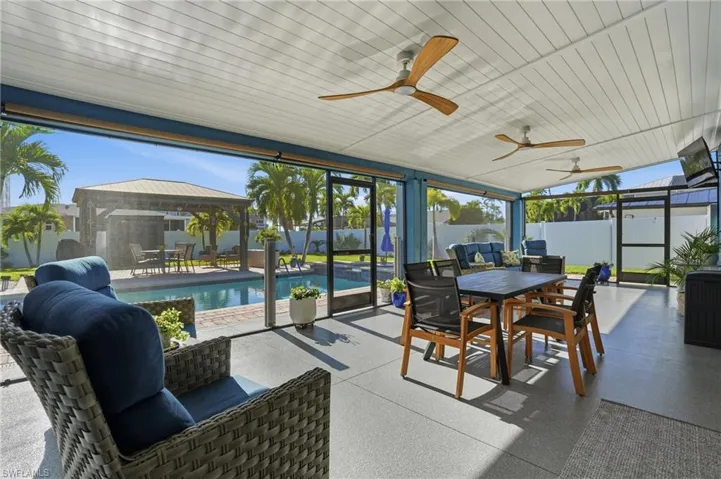Sunroom featuring outdoor dining space, a patio, a gazebo, and ceiling fan - Virtually Edited Image