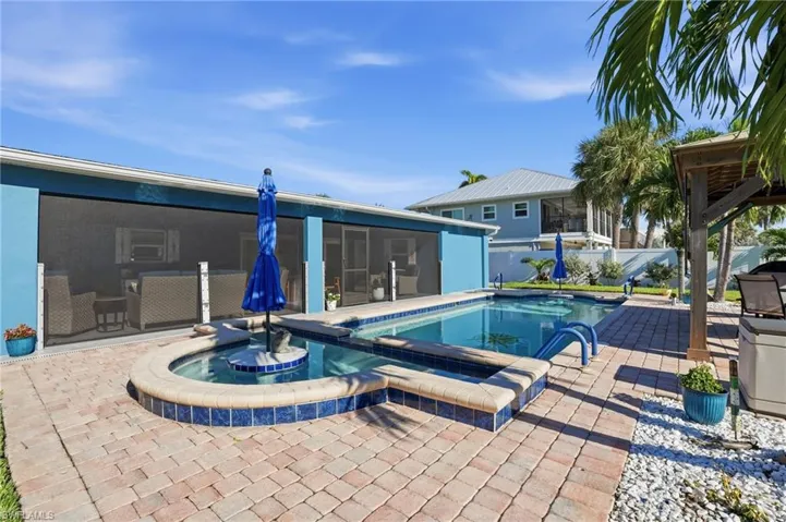 View of pool with a patio, a pool with connected hot tub, and a sunroom - Virtually Edited Image