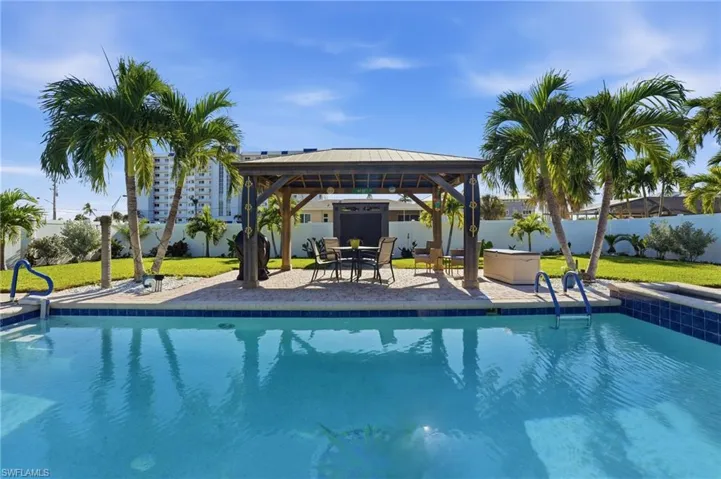 View of pool featuring a gazebo, a fenced backyard, and a patio area - Virtually Edited Image