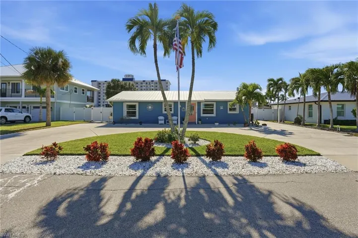 Single story home featuring expansive curved driveway and a metal roof - Virtually Edited Image