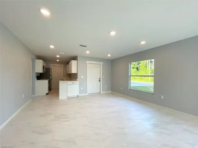 Unfurnished living room with recessed lighting and baseboards