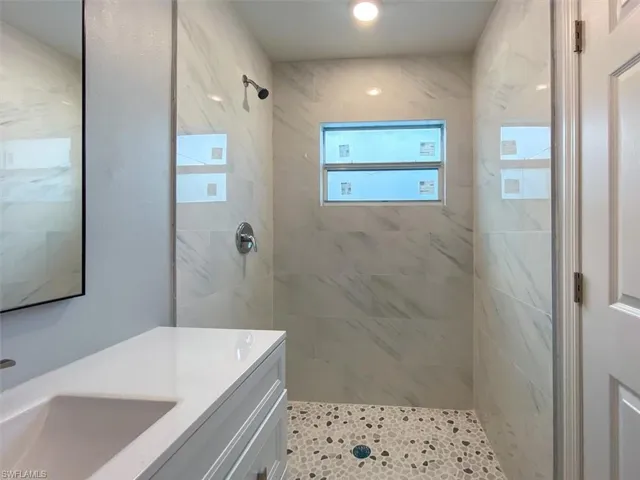 Full bathroom with a marble finish shower and vanity
