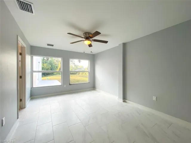 Unfurnished room with ceiling fan and baseboards