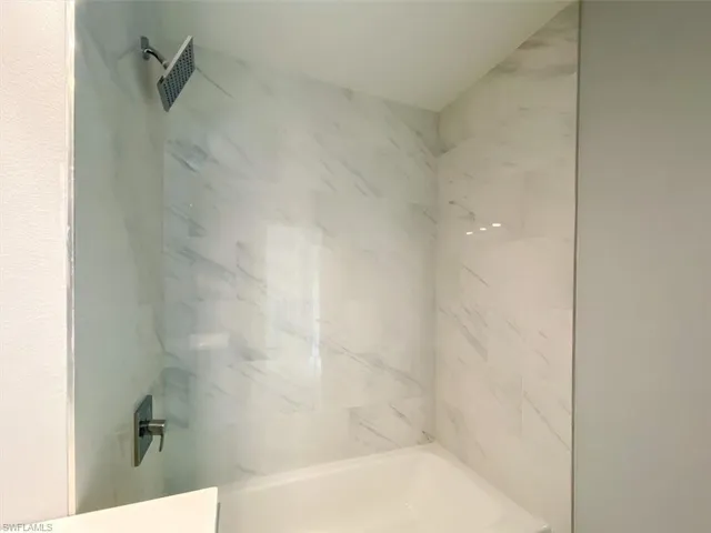 Full bathroom with a combined bath / shower with marble appearance