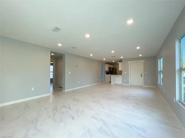 Unfurnished living room with baseboards and recessed lighting