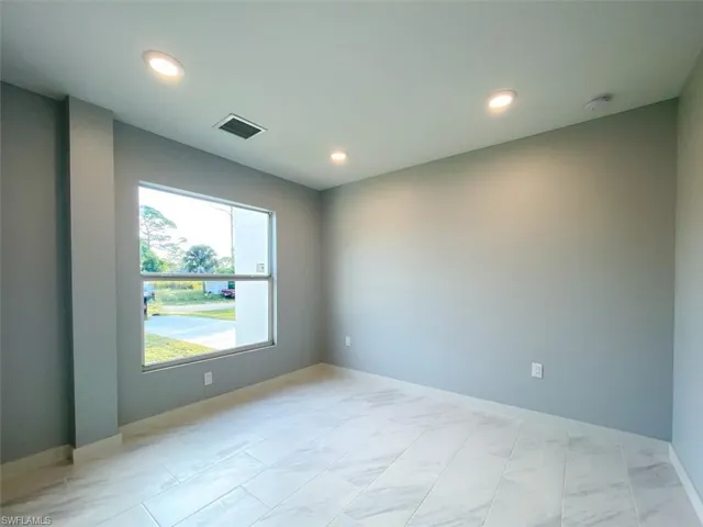 Spare room featuring light marble finish flooring and recessed lighting