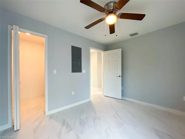 Unfurnished bedroom with a ceiling fan and electric panel