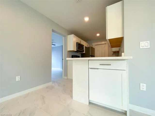 Kitchen with white cabinets, stainless steel appliances, and a peninsula