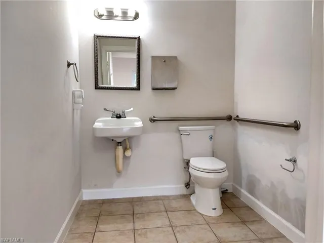 Half bath featuring toilet and light tile patterned floors