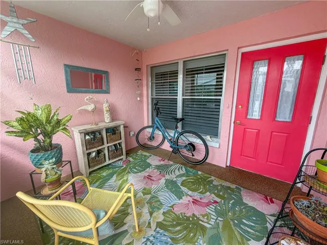 Property entrance featuring ceiling fan and stucco siding
