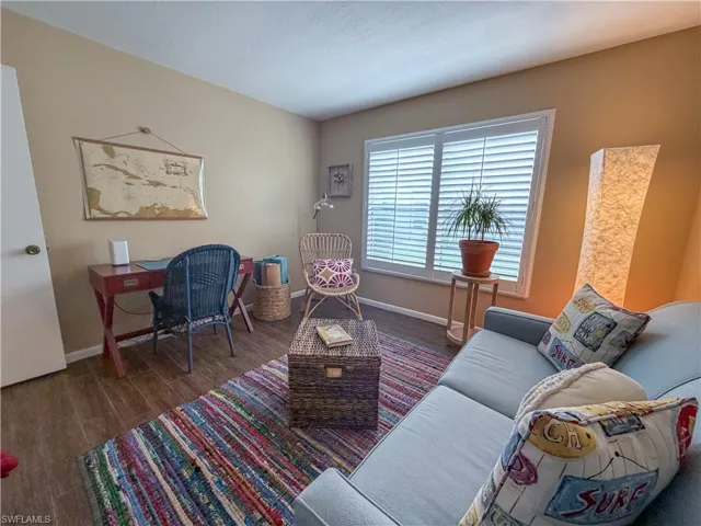 Living area with dark wood-style floors and an office area