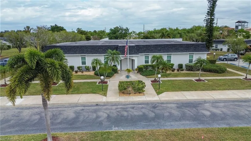 View of front of house featuring stucco siding, roof with shingles, and a front lawn