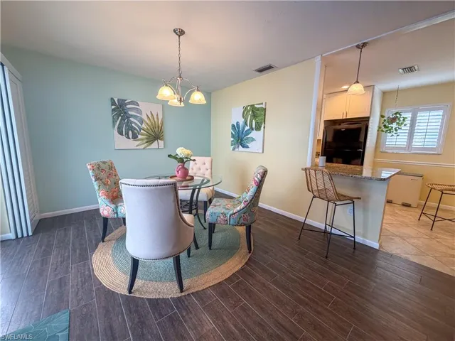Dining room with wood tiled floors and a chandelier