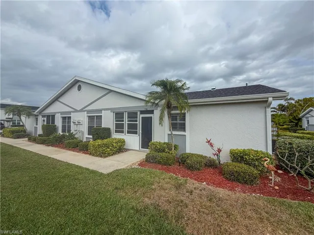 Ranch-style house with a front lawn, stucco siding, and a shingled roof