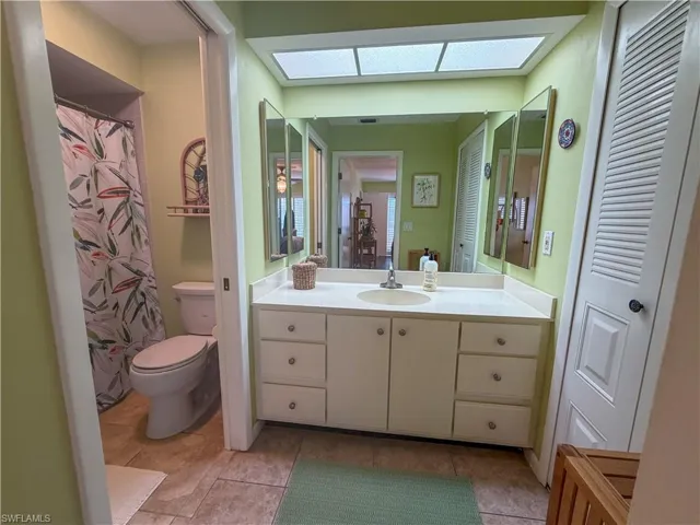 Full bath featuring curtained shower, vanity, and light tile patterned flooring