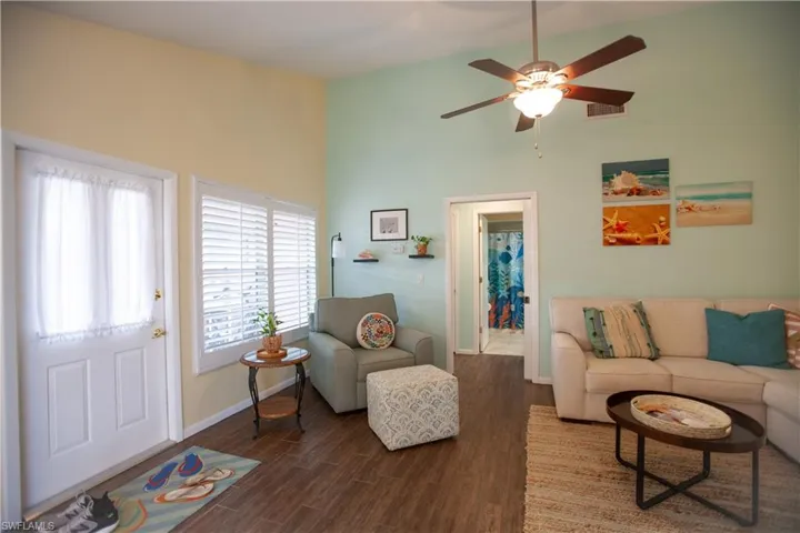 Living room with dark wood-type flooring and a ceiling fan