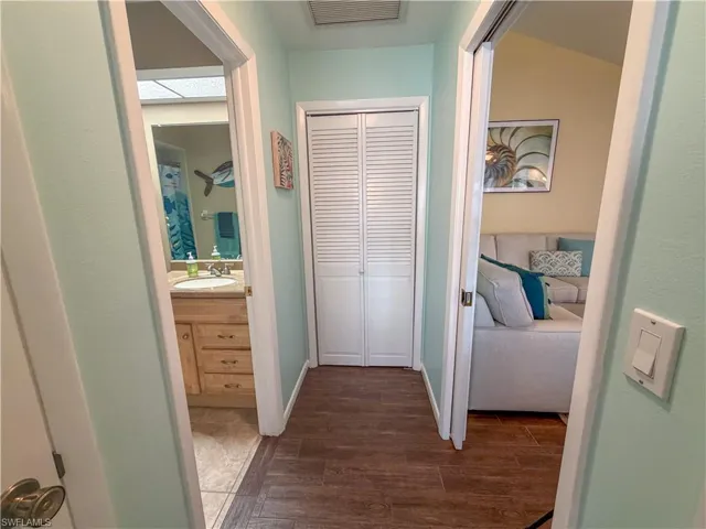 Hallway featuring dark wood-style flooring and a sink