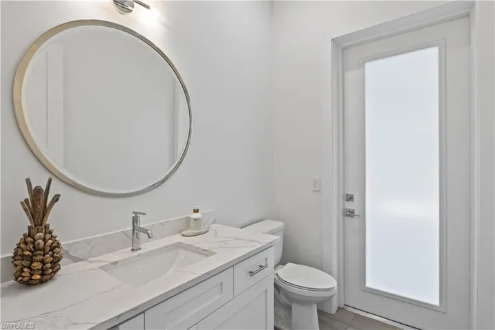 Bathroom featuring tile flooring, Solid surface vanity, and toilet