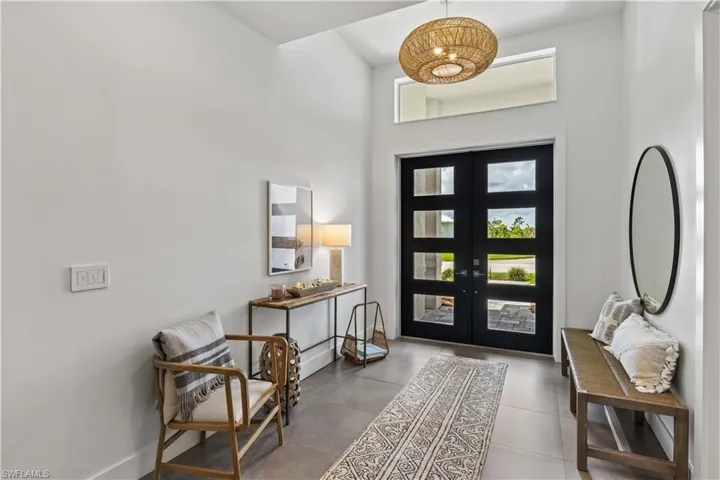 Foyer with a towering ceiling, Double entry doors, and tile floors