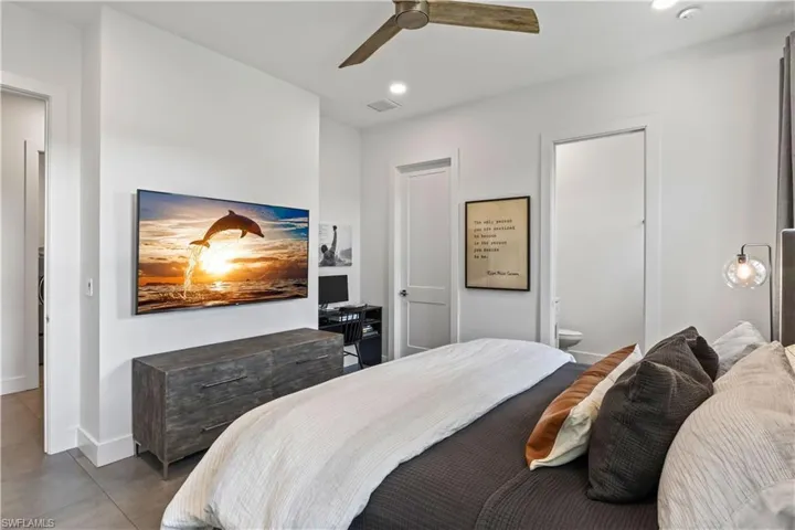 Tiled bedroom with ceiling fan and ensuite bath