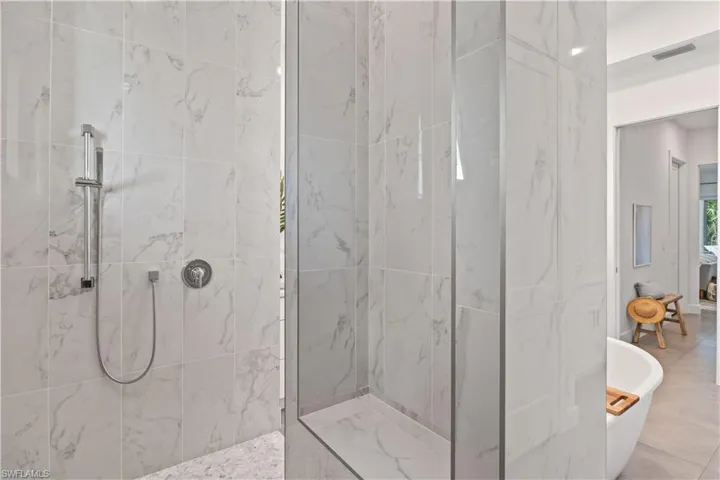 Bathroom with tile flooring and shower with separate bathtub