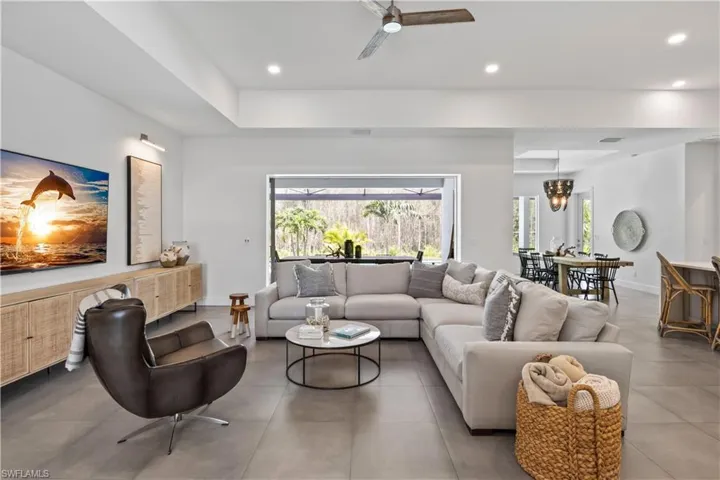 Tiled living room with a tray ceiling and ceiling fan