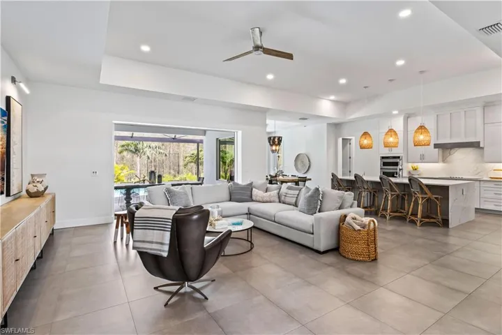 Living room with ceiling fan and light tile floors