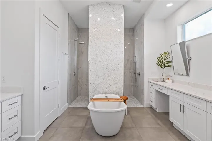 Bathroom with tile floors, plus walk in shower, and dual vanities