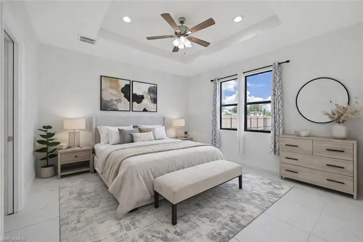 Virtually staged primary bedroom featuring a ceiling fan and recessed lighting, large window, walk in closet