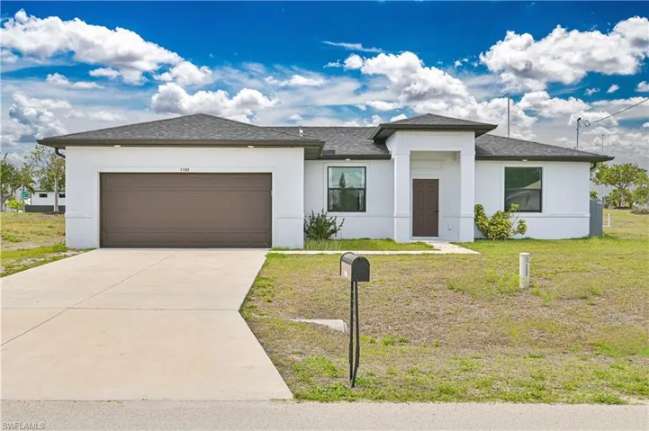 Modern style house with stucco siding, a 2+ car garage, concrete driveway, and a shingled roof