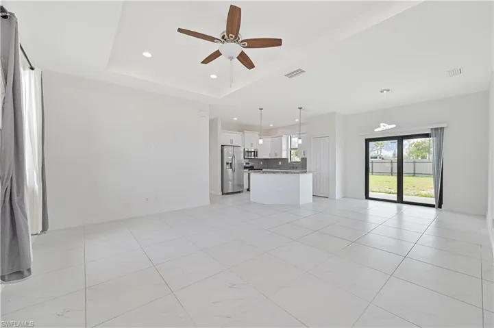 Open concept living area.  Ceiling fan, recessed lighting, and a tray ceiling
