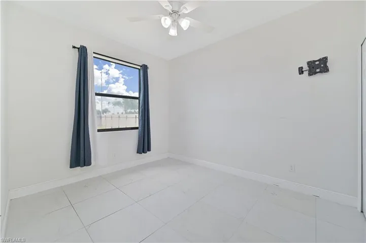 Bedroom with a ceiling fan and TV wall mount