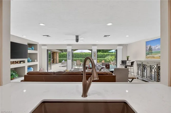 Kitchen featuring light stone counters, recessed lighting, open floor plan, ceiling fan, and a textured ceiling