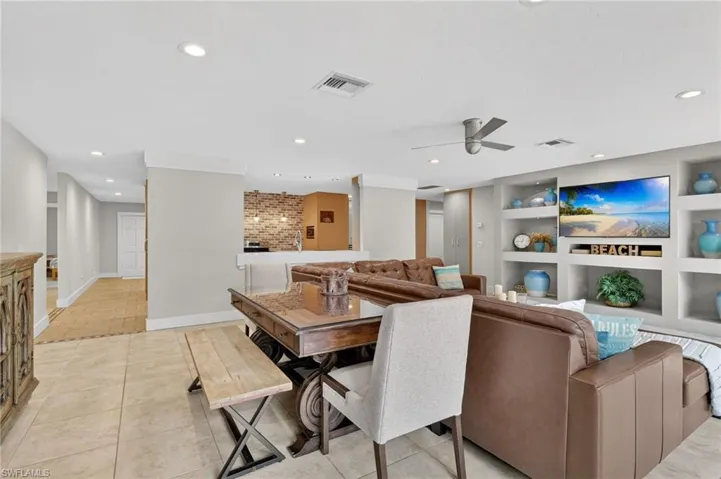 Living room with built in features, a ceiling fan, recessed lighting, and light tile patterned floors