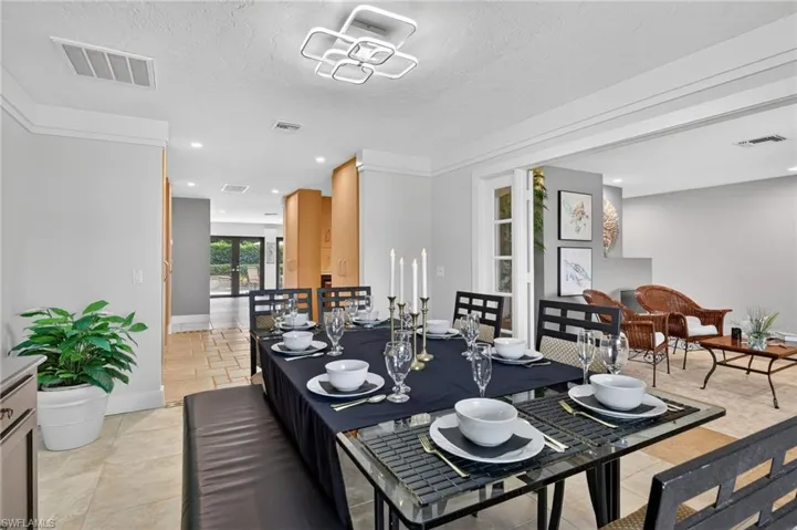 Dining space featuring french doors, a textured ceiling, and recessed lighting