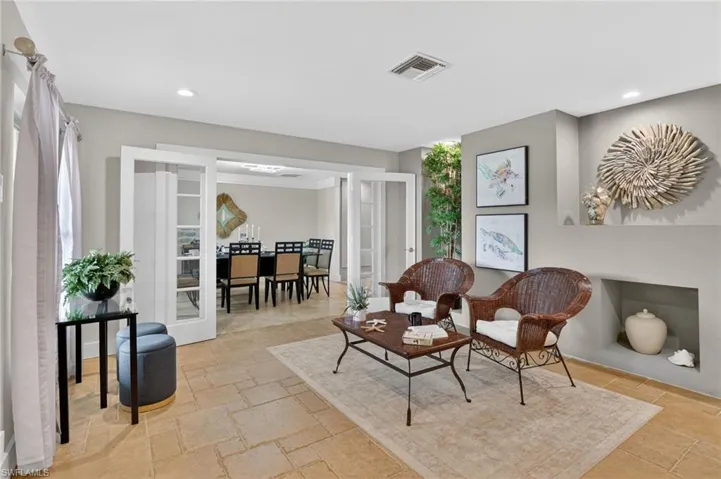 Sitting room with french doors, stone tile floors, and recessed lighting
