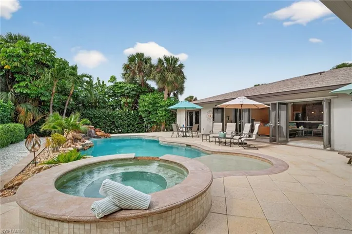 View of swimming pool with a patio area and a pool with connected hot tub