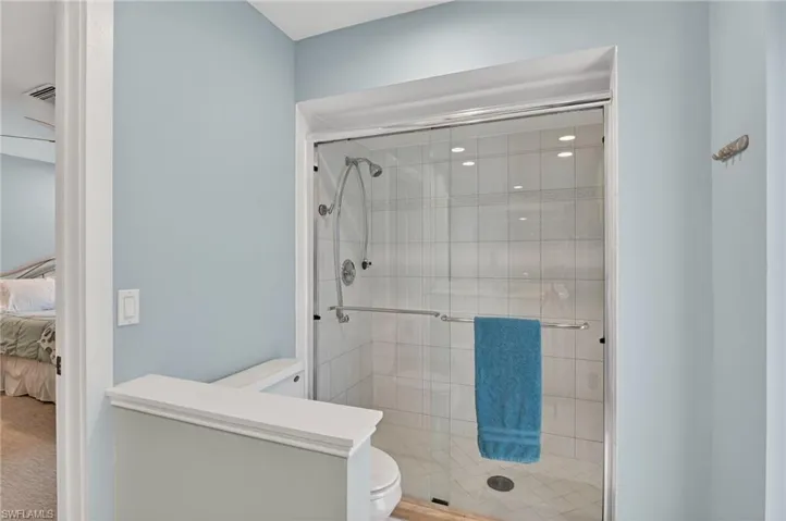 Ensuite bathroom featuring toilet and a shower stall