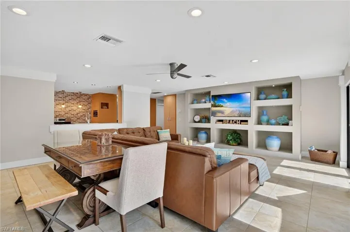 Living room with built in features, ceiling fan, recessed lighting, and light tile patterned floors