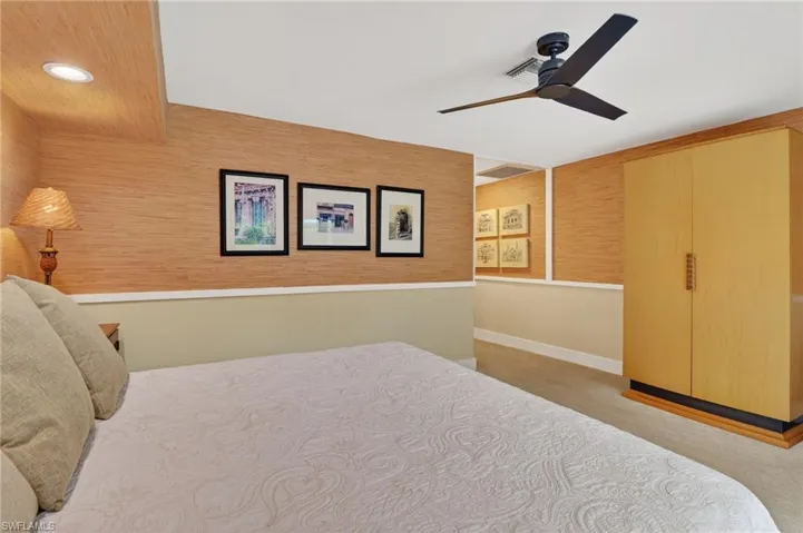 Bedroom with light carpet, ceiling fan, and recessed lighting