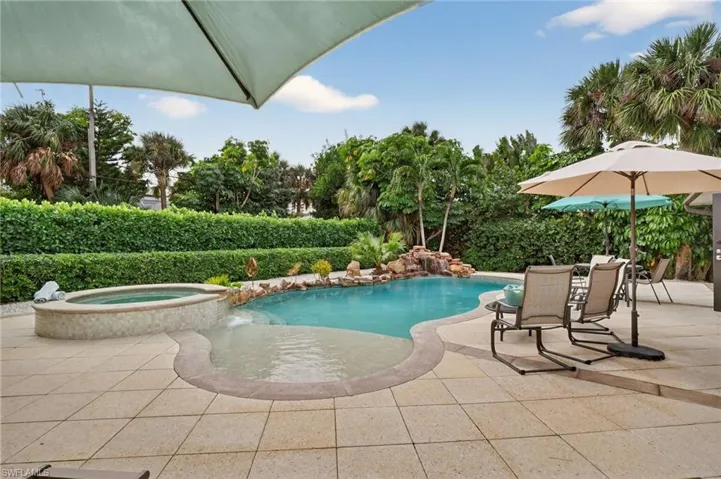 View of pool with a patio area and a pool with connected hot tub